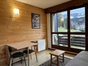 Habitación con mesa, sillas y ventana en Studio Villard-de-Lans, 1 pièce, 4 personnes - FR-1-548-41, en Villard-de-Lans
