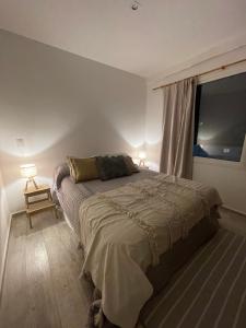 a bedroom with a bed and a large window at Casa Pancha in Pinamar