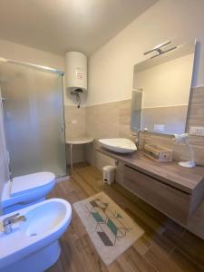 La salle de bains est pourvue de 2 toilettes, d'un lavabo et d'un miroir. dans l'établissement Il Sorriso - Appartamento con Grande Giardino e Barbecue, à Gressan