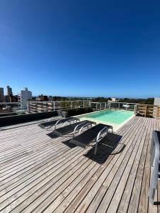 a deck with two lounge chairs and a swimming pool at Casa Pancha in Pinamar