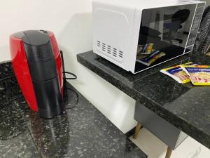 a microwave sitting on a counter next to a toaster at Loft no Espinheiros - Joinville/SC in Joinville