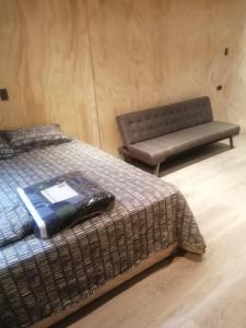 a room with two beds and a bench in it at TinyHouse Box Lican Ray in Licán Ray +16 photos