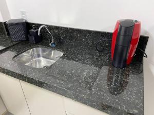um balcão de cozinha com um lavatório e um aparelho em Loft no Espinheiros - Joinville/SC em Joinville