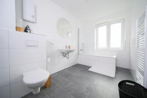 a white bathroom with a toilet and a sink at Deluxe Apartments - 1 & 2 Bedroom - Zentral - 10 Min Messe in Düsseldorf