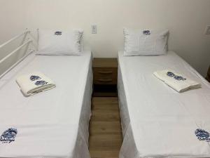two beds sitting next to each other in a room at Loft no Espinheiros - Joinville/SC in Joinville