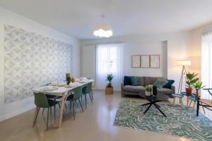 een eetkamer en een woonkamer met een tafel en stoelen bij Green Cocon - Belle maison pour 8 in Agen