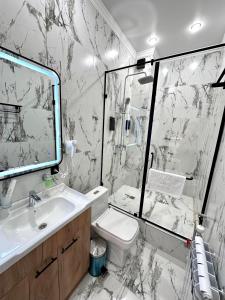 a bathroom with a toilet and a sink and a shower at Freedom hotel in Almaty