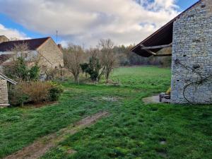 a barn in a field with a grass yard at Gite les Frênes avec pré dans joli hameau in Vermenton