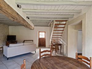 a living room with a table and a couch at Gite les Frênes avec pré dans joli hameau in Vermenton