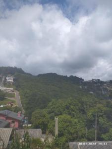 - une vue sur une montagne avec un bâtiment et des arbres dans l'établissement Pousada Águia da Serra Gramado 1, à Gramado