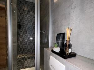 a bathroom with a shower and a vase with bamboo sticks at Ferienhaus Harzglück in Bad Lauterberg +14 photos