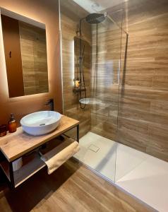 a bathroom with a sink and a shower at La Jardinière in Érezée