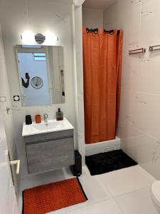bagno con lavandino e tenda doccia arancione di CYRUS Hôtel -Housse cœur de ville a Pointe-à-Pitre Altre 37 foto