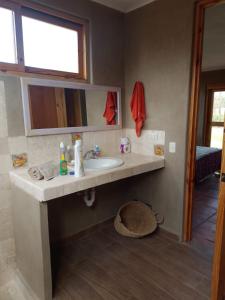 a bathroom with a sink and a mirror at Alquiler Casa Campo Ica in Ronceros Bajo