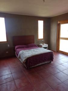 a bedroom with a bed and a tiled floor at Alquiler Casa Campo Ica in Ronceros Bajo