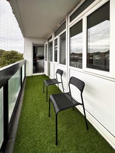 two chairs sitting on a balcony with green grass at Penny's Place in Grove Park in Eltham