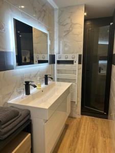 a white bathroom with a sink and a stove at ARC EN CIEL B&B in Pontorson