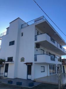 un edificio blanco con balcones laterales en Alexandra Studios, en Néos Pírgos