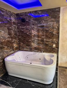 a white bath tub in a bathroom with tiles at Hotel Diamant in Dospat +13 photos