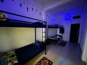 2 łóżka piętrowe w pokoju z fioletowymi lampkami w obiekcie Spiritual Backpackers Hostel w mieście Ujjain