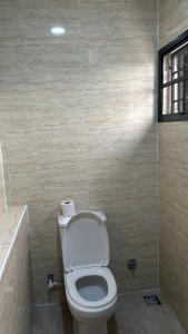 a small bathroom with a toilet and a shower at Geminge shortlet in Port Harcourt