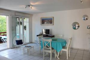 uma sala de estar com mesa e cadeiras em appartement cosy et nature au coeur du Bassin em Arès