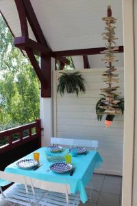 uma mesa azul com pratos de comida num pátio em appartement cosy et nature au coeur du Bassin em Arès