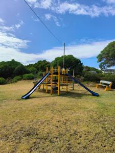 a playground with a slide in a field at Strictly-Halaal Holiday Home at Meerensee Resort in Fisherhaven