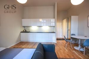 a kitchen and a living room with a couch and a table at Przytulny Apartament w centrum Kazimierza in Krakow