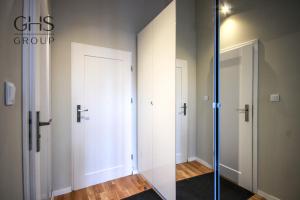 a room with two white doors and a glass doorway at Przytulny Apartament w centrum Kazimierza in Krakow