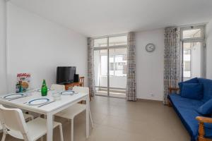 a living room with a white table and a blue couch at TAC - Fisherman's Beach Apartment in Albufeira