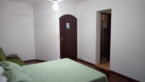 a room with a bed and a door and a room with a chair at Hotel Moinho de Pedra in Serra Negra