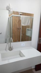 a bathroom with a sink and a mirror at Hotel Moinho de Pedra in Serra Negra