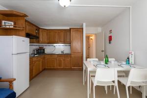 a kitchen with a table and chairs and a white refrigerator at TAC - Fisherman's Beach Apartment in Albufeira