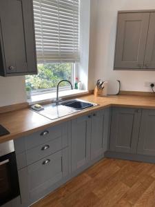 eine Küche mit Spüle und Fenster in der Unterkunft CLITHEROE TOWN CENTRE MODERN 2 BED APARTMENT in Clitheroe