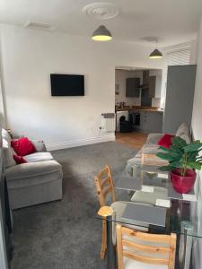 ein Wohnzimmer mit Sofa und Tisch in der Unterkunft CLITHEROE TOWN CENTRE MODERN 2 BED APARTMENT in Clitheroe