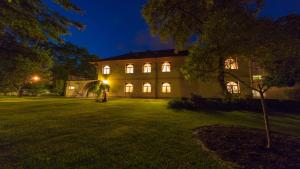 a building with lights on in a yard at night at Penzion Flídr in Poděbrady