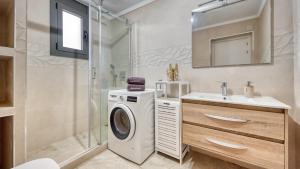 a bathroom with a washing machine and a sink at Costacabana - Villa Palmera in Lloret de Mar