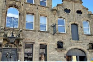 an old brick building with many windows on it at CLITHEROE TOWN CENTRE MODERN 2 BED APARTMENT in Clitheroe