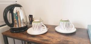 two tea pots on a wooden table with a blender at "Les Lauriers" chambre d'hôtes indépendante avec terrasse privée in Moustiers-Sainte-Marie