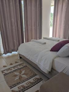 2 camas en un dormitorio con cortinas rosas en Awali Villa B33, en Vipingo