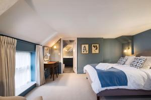 a bedroom with a large bed and a desk at Great Escapes Oundle Flat 2 in Oundle