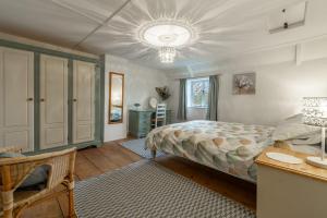 a bedroom with a bed and a chandelier at Lovely Cottage in North Creake