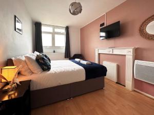 a bedroom with a bed and a tv on the wall at Penny's Place in Grove Park in Eltham