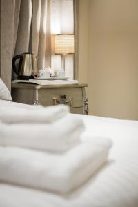 埃克塞特的住宿－埃克斯特菲爾奧克豪斯旅館，一间卧室配有一张床和一张带台灯的桌子