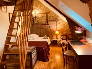 um quarto no sótão com uma cama e uma escada em Maison d'hôtes et gîte au Manoir de la Haute Pilais em Chantepie