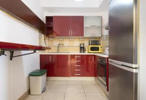 uma cozinha com armários vermelhos e um frigorífico de aço inoxidável em Casa Bella Lucía em Casablanca