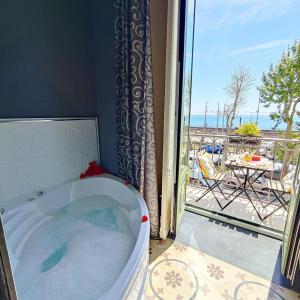 a bath tub in a room with a view of a patio at B&B I Puritani in Catania