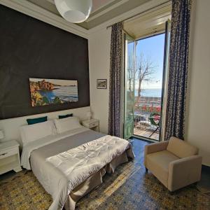 a bedroom with a bed and a window and a chair at B&B I Puritani in Catania