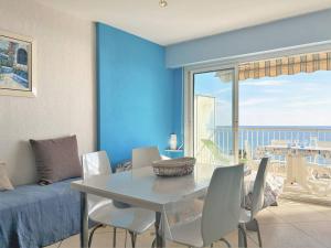 comedor con mesa y pared azul en Appartement Le Lavandou, 1 pièce, 3 personnes - FR-1-251-252, en Le Lavandou